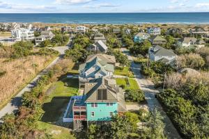an aerial view of a neighborhood with houses and the ocean at 7200 - Better Surf Than Sorry in Salvo