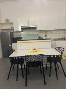 a kitchen with a white table and chairs in it at Tower casa vacanze 1 in Anzio