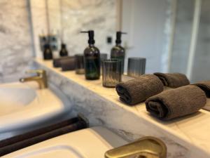 a bathroom counter with a sink and towels on a shelf at Sky Loft Schwarzach in Schwarzenbruck +27 photos