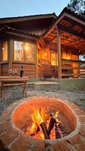 a fire pit in front of a log cabin at Cabanas Green Valley in Monte Verde