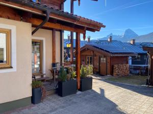 a house with a porch with potted plants on it at Ferienwohnung Lederhose in Bischofswiesen