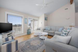 a living room with a couch and a tv at 7158 - A Wave From It All in Waves