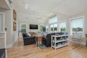 a living room with a couch and a tv at 1064 - Sunset Cottage in Corolla