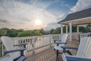 a deck with white chairs and a gazebo at 1064 - Sunset Cottage in Corolla