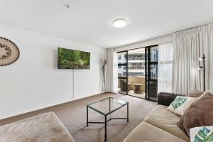 a living room with a couch and a glass table at Ocean Seascape - Mt Maunganui in Mount Maunganui