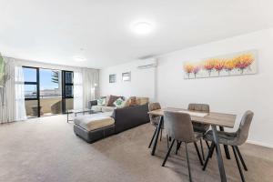 a living room with a table and a couch at Ocean Seascape - Mt Maunganui in Mount Maunganui