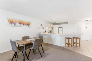a kitchen and dining room with a wooden table and chairs at Ocean Seascape - Mt Maunganui in Mount Maunganui +9 photos