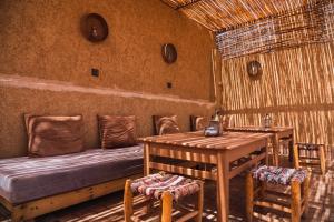 a room with a bed and a table and chairs at Dar Duna in Adrouine