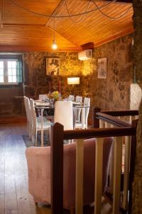 a dining room with a table and white chairs at Refugio dos Cartolas - Mountain Retreat in São Mamede