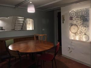 a dining room with a table and chairs and a mirror at Loft with a ducal view in Urbino +8 photos
