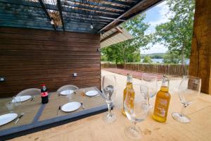 a wooden table with wine bottles and glasses on it at Le chalet au bord de seine in Les Mousseaux