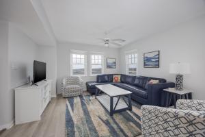 a living room with a blue couch and a tv at 7766 - Striper in Buxton
