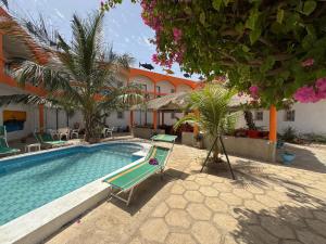 a swimming pool with a lounge chair next to a building at Hôtel évasion pêche djilor île sine saloum in Fatick +21 photos