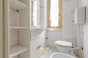 a white bathroom with a toilet and a sink at Casa dell'amicizia in Milan