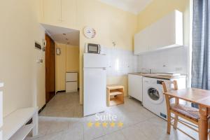 a kitchen with a white refrigerator and a table at Casa dell'amicizia in Milan