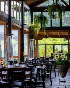 a restaurant with wooden tables and chairs and plants at Finca San Cayetano in San Juan Alotenango