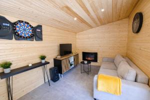 a living room with a couch and a dartboard at Le chalet au bord de seine in Les Mousseaux