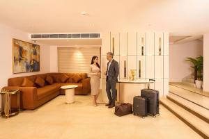 a man and a woman standing in a living room at Liza Royale Hotel Near Chennai central Railway Station in Chennai