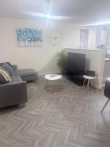 a living room with a couch and a flat screen tv at Golden Stay in Wyken