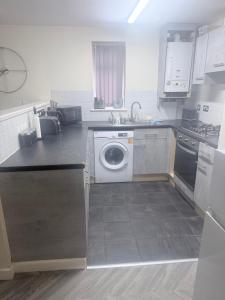 a kitchen with a washing machine and a sink at Golden Stay in Wyken +9 photos
