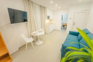 a living room with a blue couch and a table at Apartamentos Aires de Conil in Conil de la Frontera