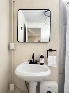 a bathroom with a white sink and a mirror at Suite 02 Montenegro Cerca de Consulado in Monterrey