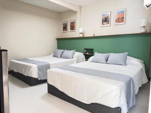 two beds in a room with green and white at Suite 02 Montenegro Cerca de Consulado in Monterrey +7 photos