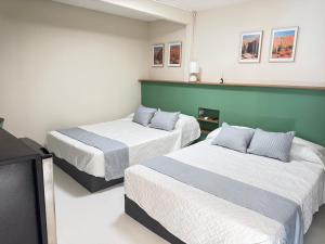 a room with two beds and a television at Suite 02 Montenegro Cerca de Consulado in Monterrey