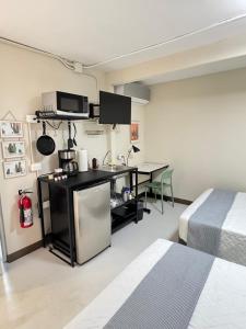 a room with a kitchen and a table and a bed at Suite 02 Montenegro Cerca de Consulado in Monterrey