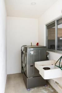 a laundry room with a washing machine and a sink at Quiet and comfortable space in Aguascalientes