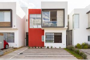 a red door on a white house at Quiet and comfortable space in Aguascalientes