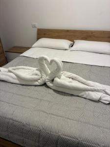 two towel swans sitting on top of a bed at Vicolo Lungo Apartment in Nardò
