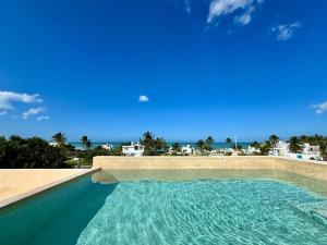 a swimming pool with a view of the ocean at Panoramic Ocean Views - Villa Home Chelem in Chelem
