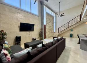 a living room with a couch and a flat screen tv at Panoramic Ocean Views - Villa Home Chelem in Chelem