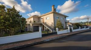 a house on the side of a street with a white fence at Moradia santa comba in Santa Comba Dão