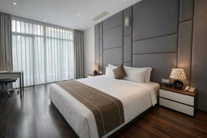 a bedroom with a large bed and a desk at KP Hotel in Can Tho +79 photos