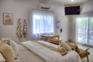 a bedroom with a large bed and a desk and window at Solis in Agnes Water in Agnes Water