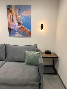 a couch in a living room with a painting on the wall at CityView Lodge in Chişinău
