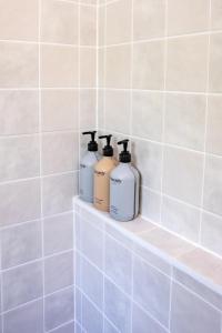 three bottles ofodorizers sit on a shelf in a bathroom at Solis in Agnes Water in Agnes Water