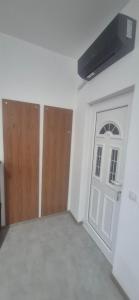 an empty room with a white door and wooden doors at Odmorište Noćko in Valjevo