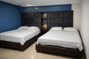 two beds sitting next to each other in a bedroom at Hotel calima royal in Cali