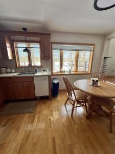 a kitchen with a table and a table and chairs at UPTA CAMP LIMIT 8 cabin in West Baldwin