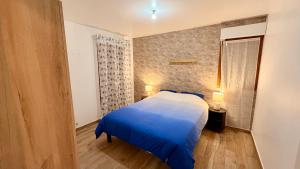 a bedroom with a blue bed in a room at Le Terrier in Noisiel