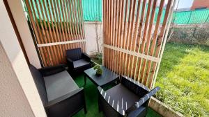 a balcony with two chairs and a table and a fence at Le Terrier in Noisiel