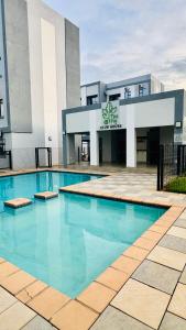 a large swimming pool in front of a building at Orchid Belvedere Suites 102 - The Fig in Gaborone