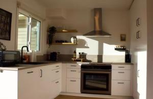 a kitchen with white cabinets and a stove at Brùn House in Fort Saint John +10 photos