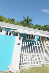 a blue and white house with a white fence at Dawson’s Hideaway in Nassau