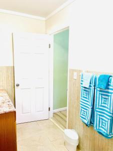 a bathroom with blue towels hanging on a wall at Dawson’s Hideaway in Nassau +52 photos