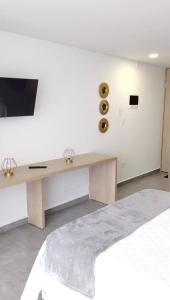 a white room with a desk with a television on a wall at Estocolmo in Armenia