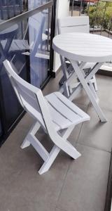 a white table and chair sitting next to a window at Estocolmo in Armenia
